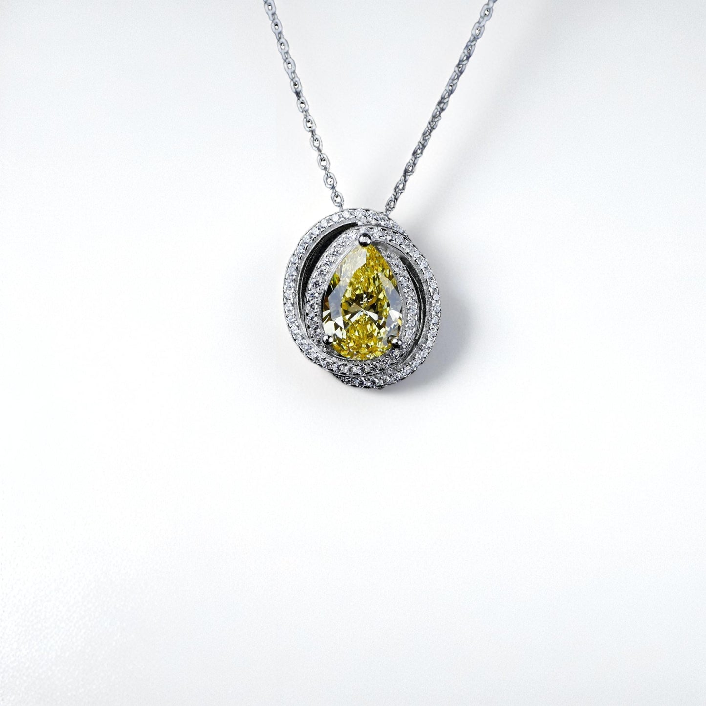 Diamond necklace with a yellow pear-shaped gemstone on a white background