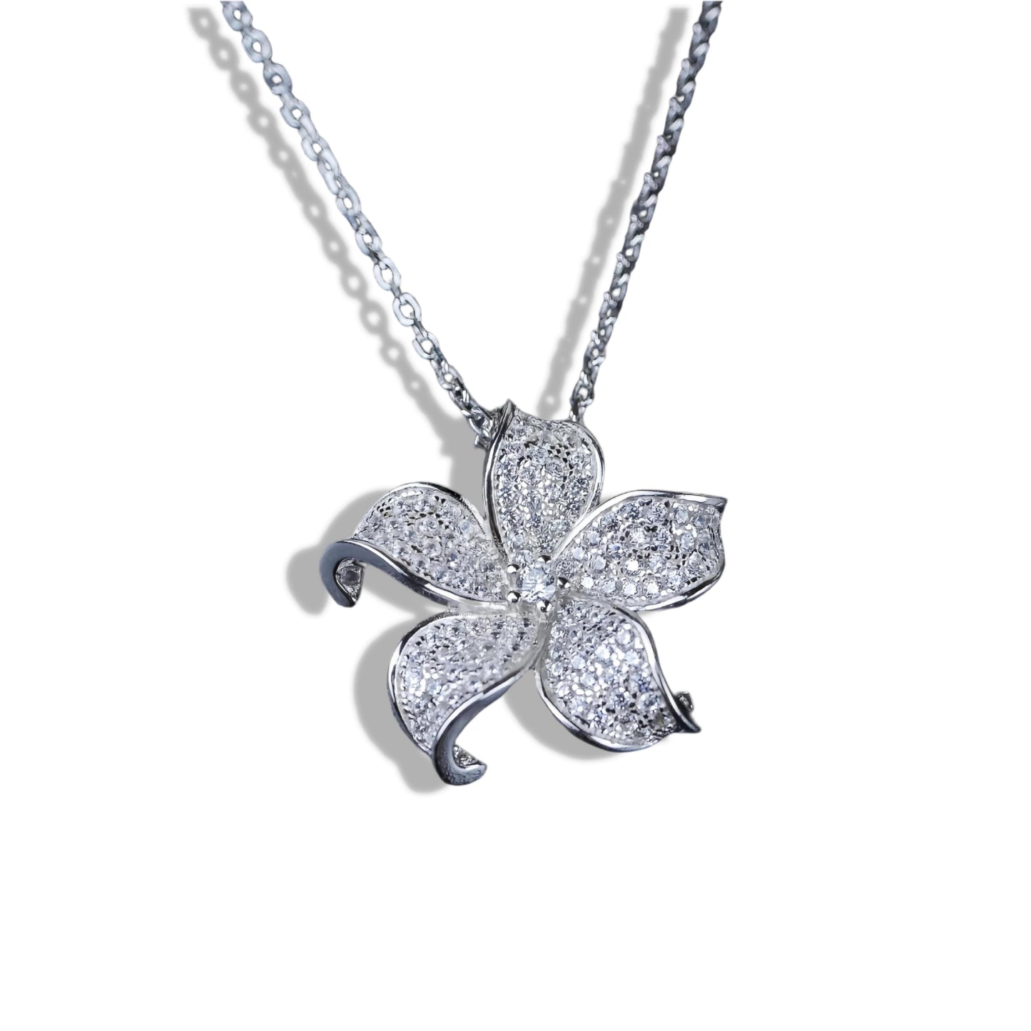 Flower-shaped diamond pendant on a chain against a white background