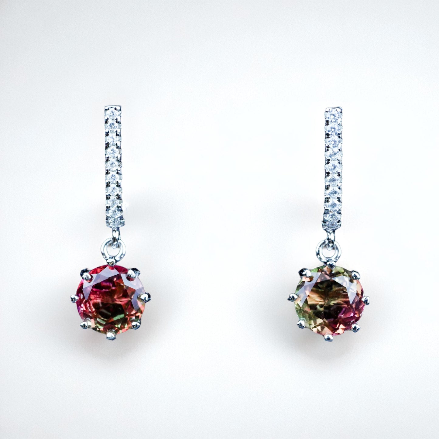 Multicolored gemstone earrings with diamond-like accents on a white background