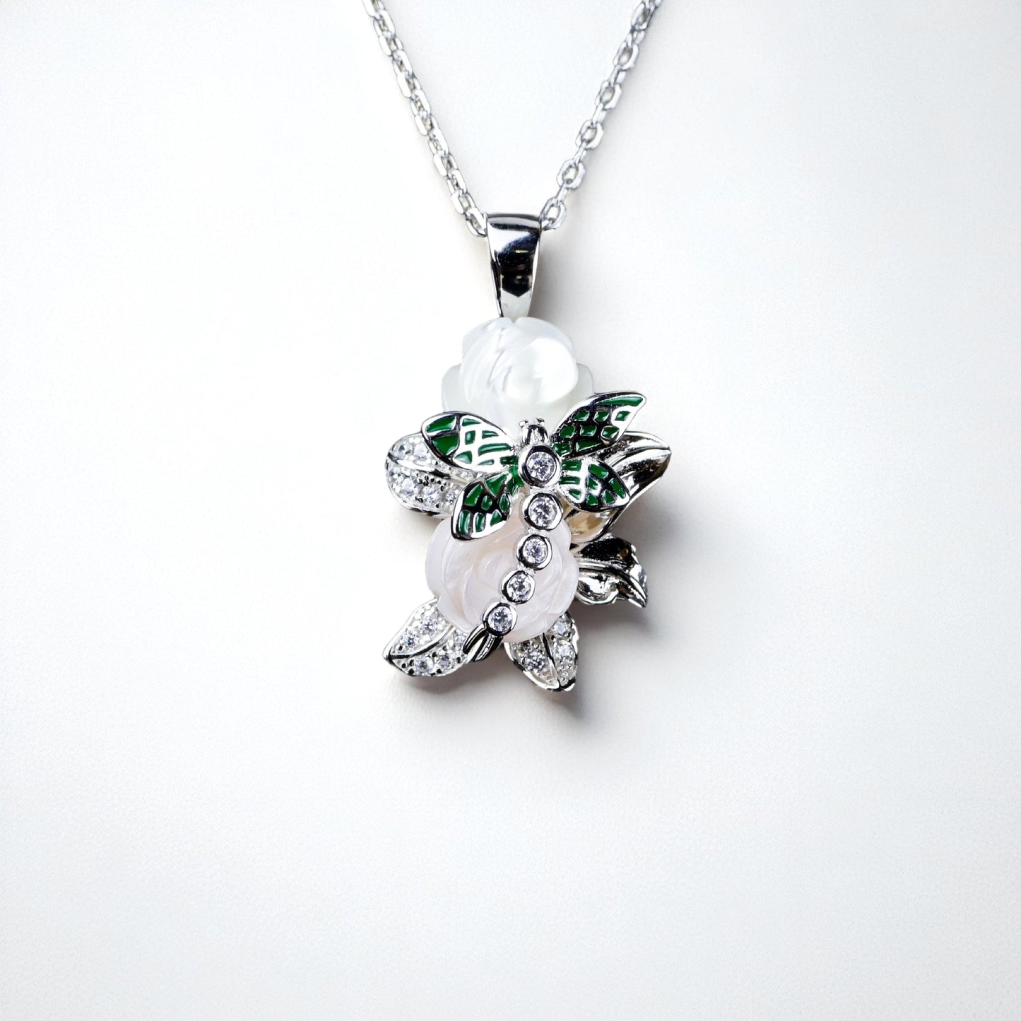 Butterfly-shaped necklace with green and white details on a white background