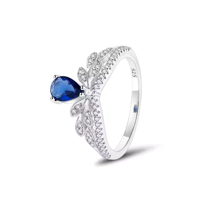 A sterling silver ring with a blue central cubic zirconia and surrounded by smaller clear cubic zirconia stones with a rhodium plating.