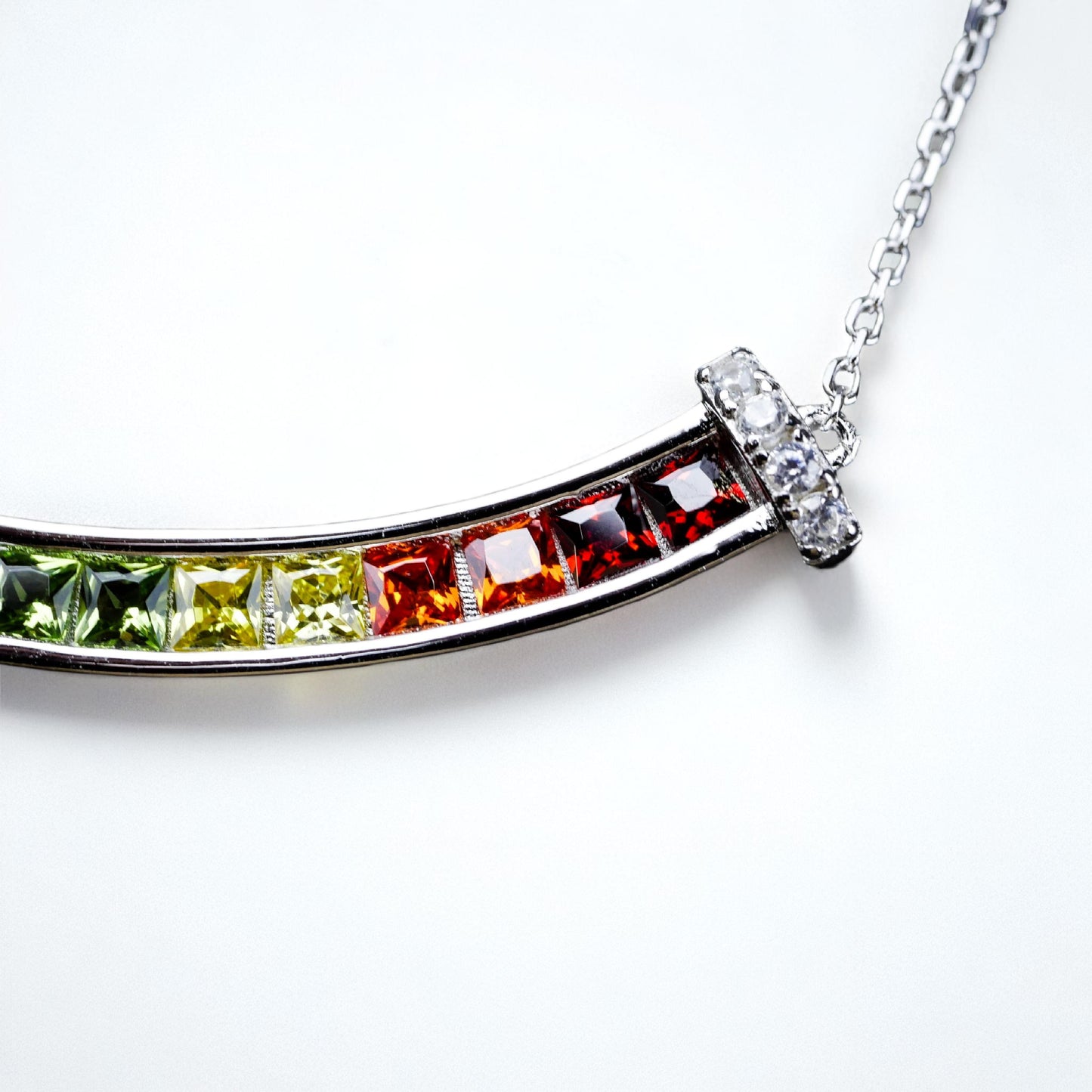 Rainbow colored smiling necklace on white background.