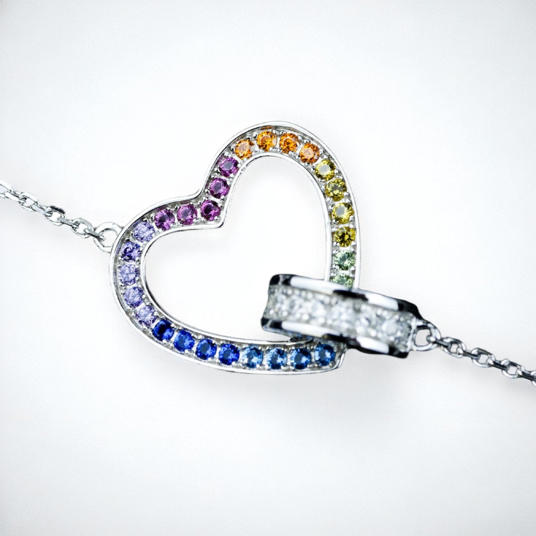 Heart-shaped jewelry with multicolored gemstones on a white background