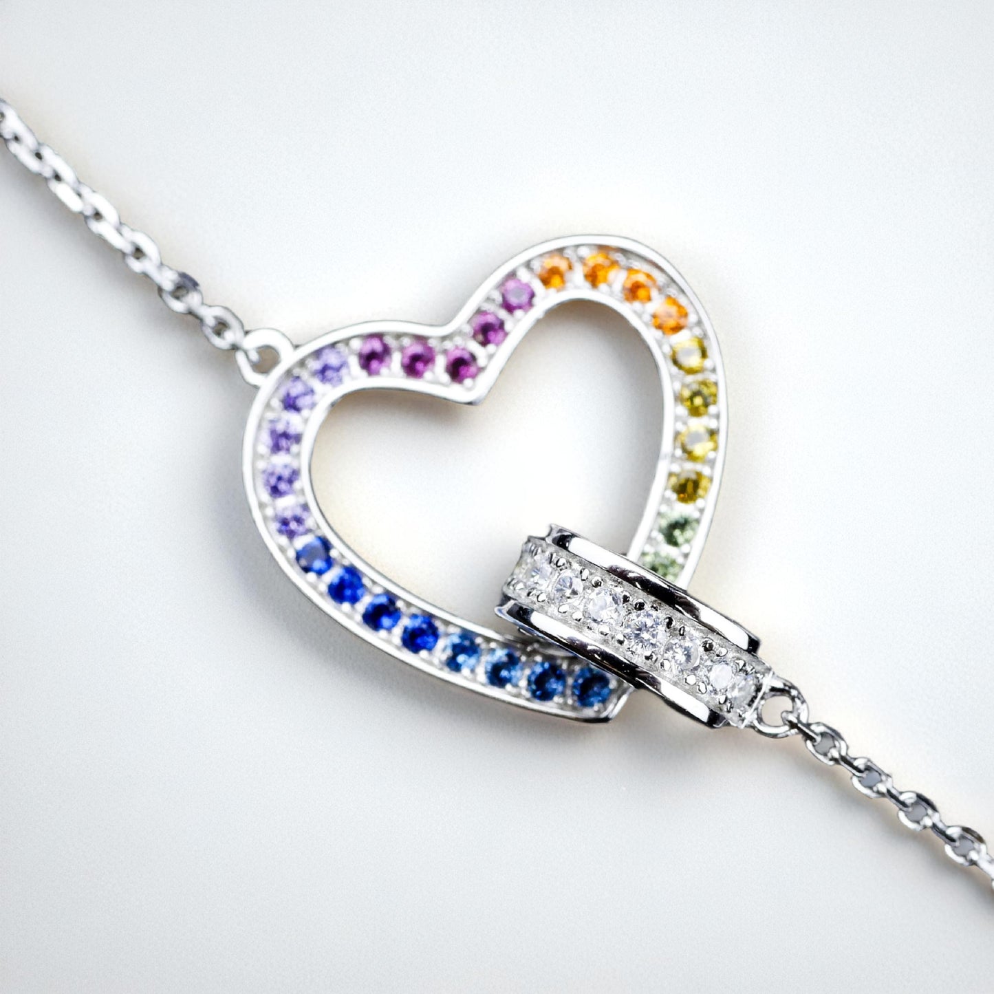 Heart-shaped necklace with colorful gemstones on a white background