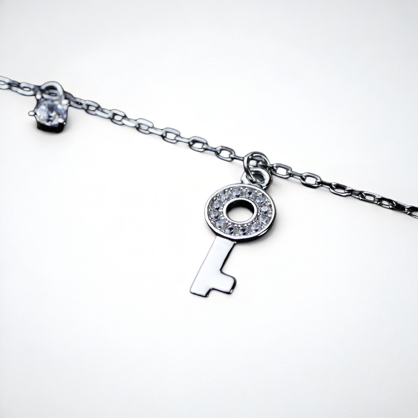 Silver key-shaped pendant on a chain against a white background