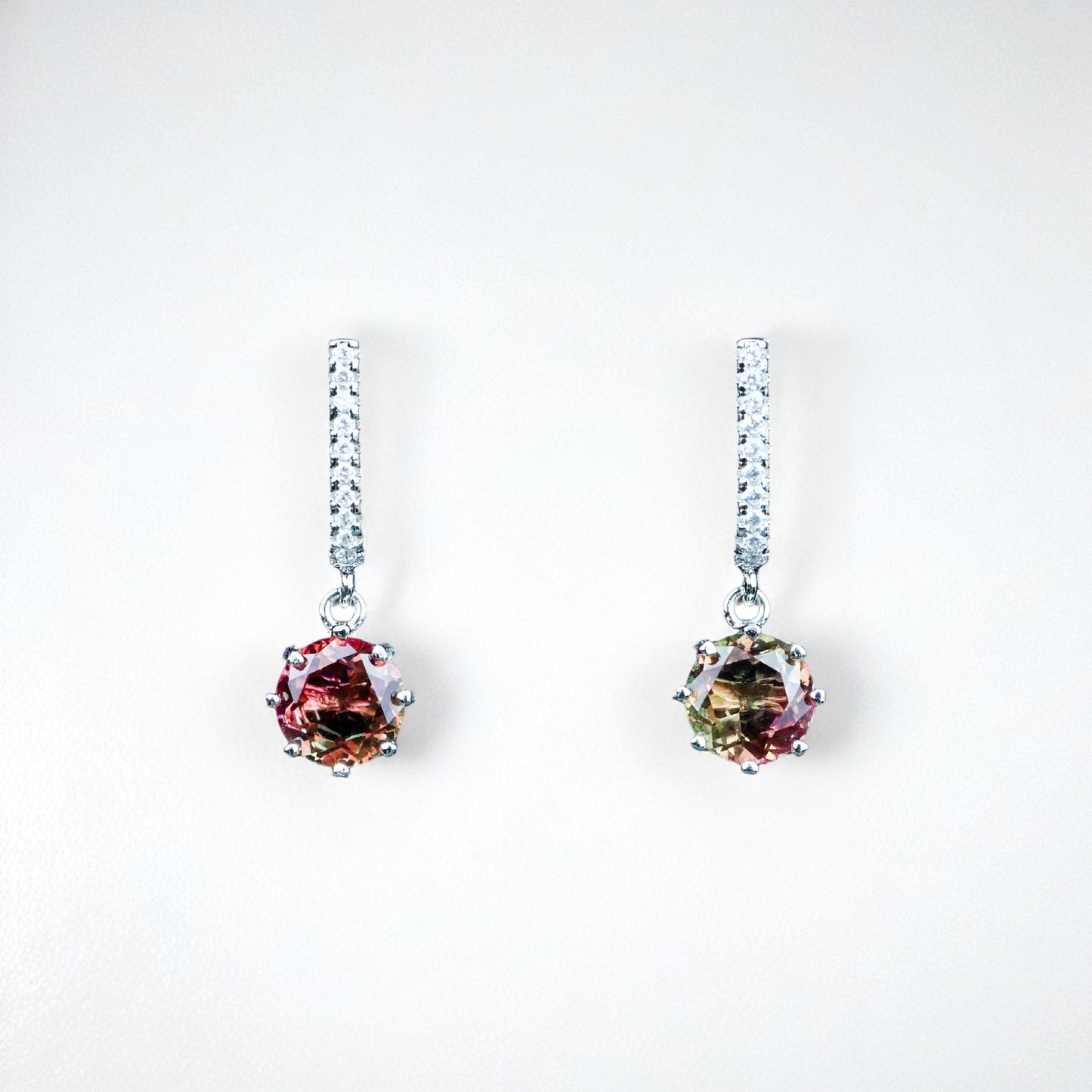 Pair of earrings with multicolored gemstones on a white background
