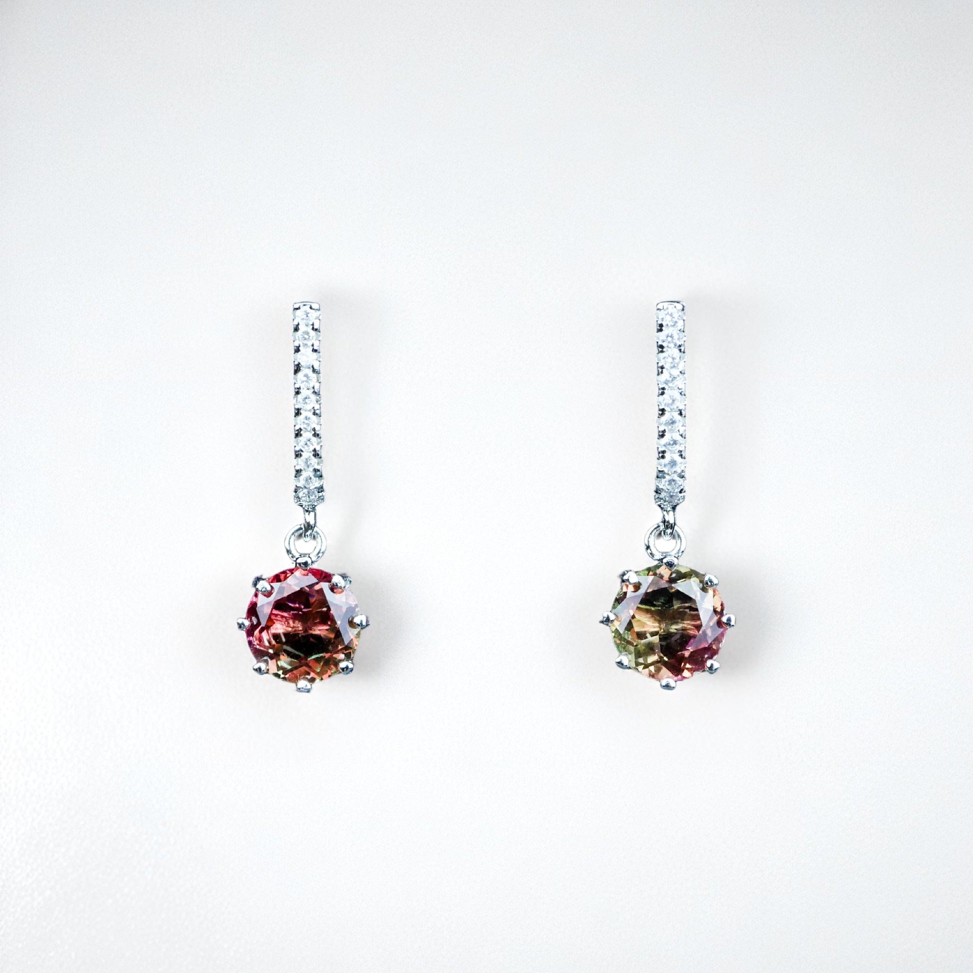 Pair of earrings with multicolored gemstones on a white background