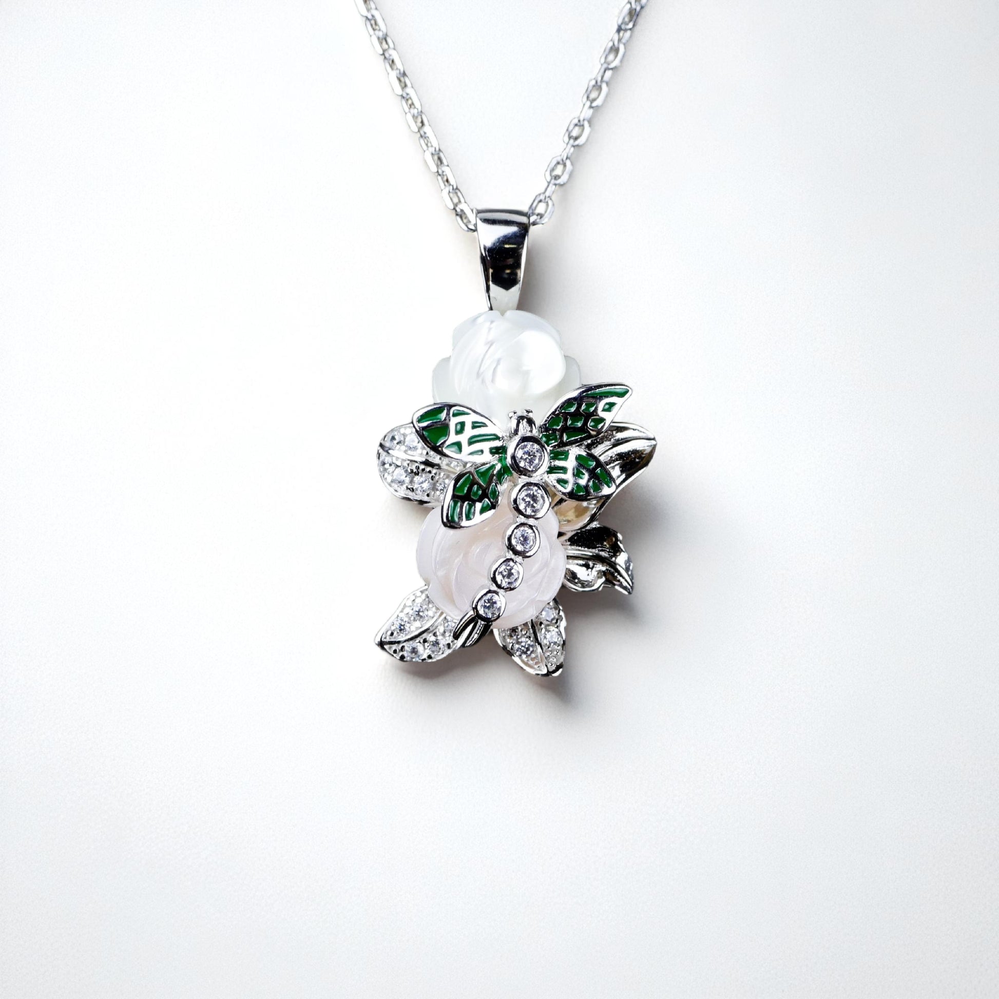 Butterfly-shaped necklace with green and white details on a white background