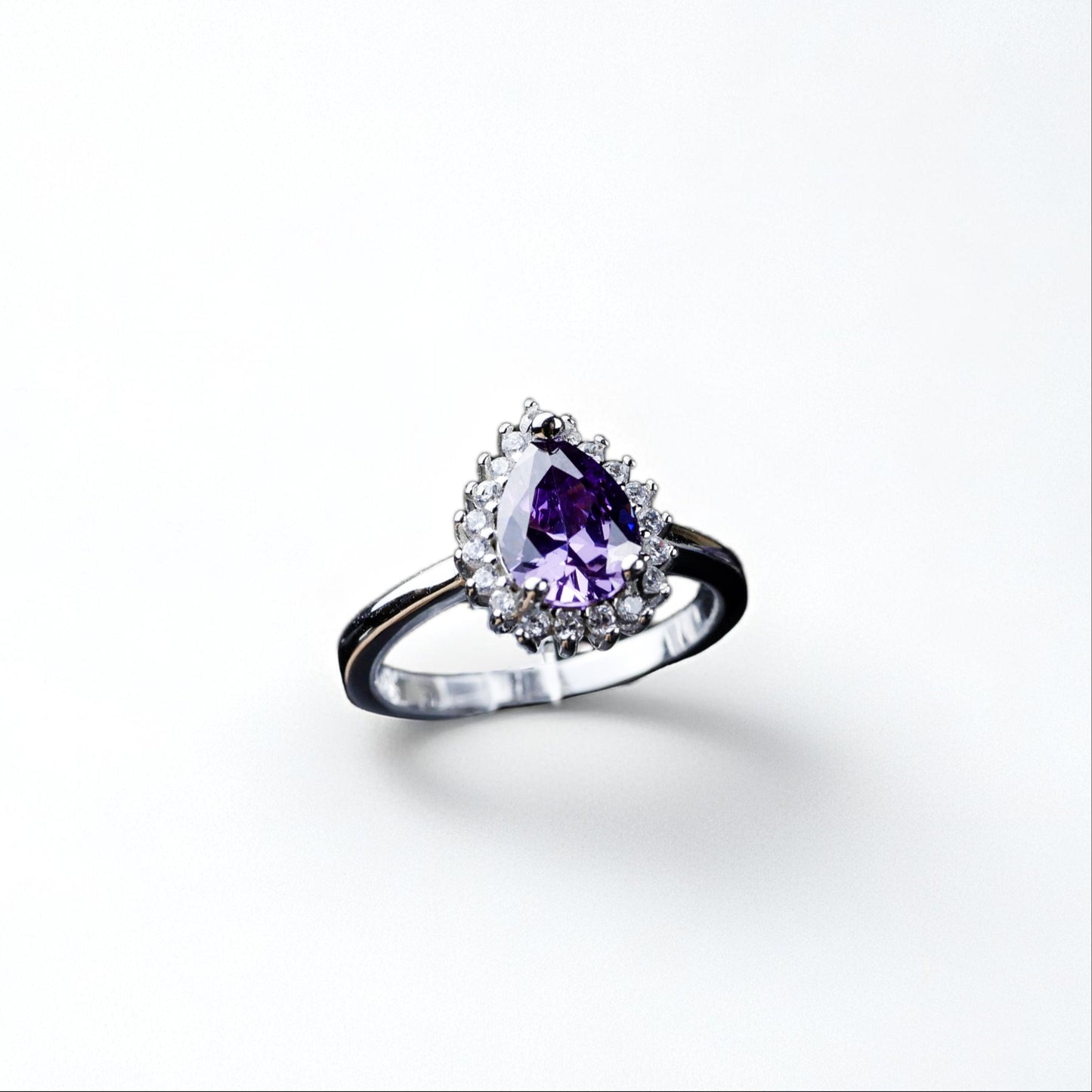 Silver ring with a purple gemstone on a white background