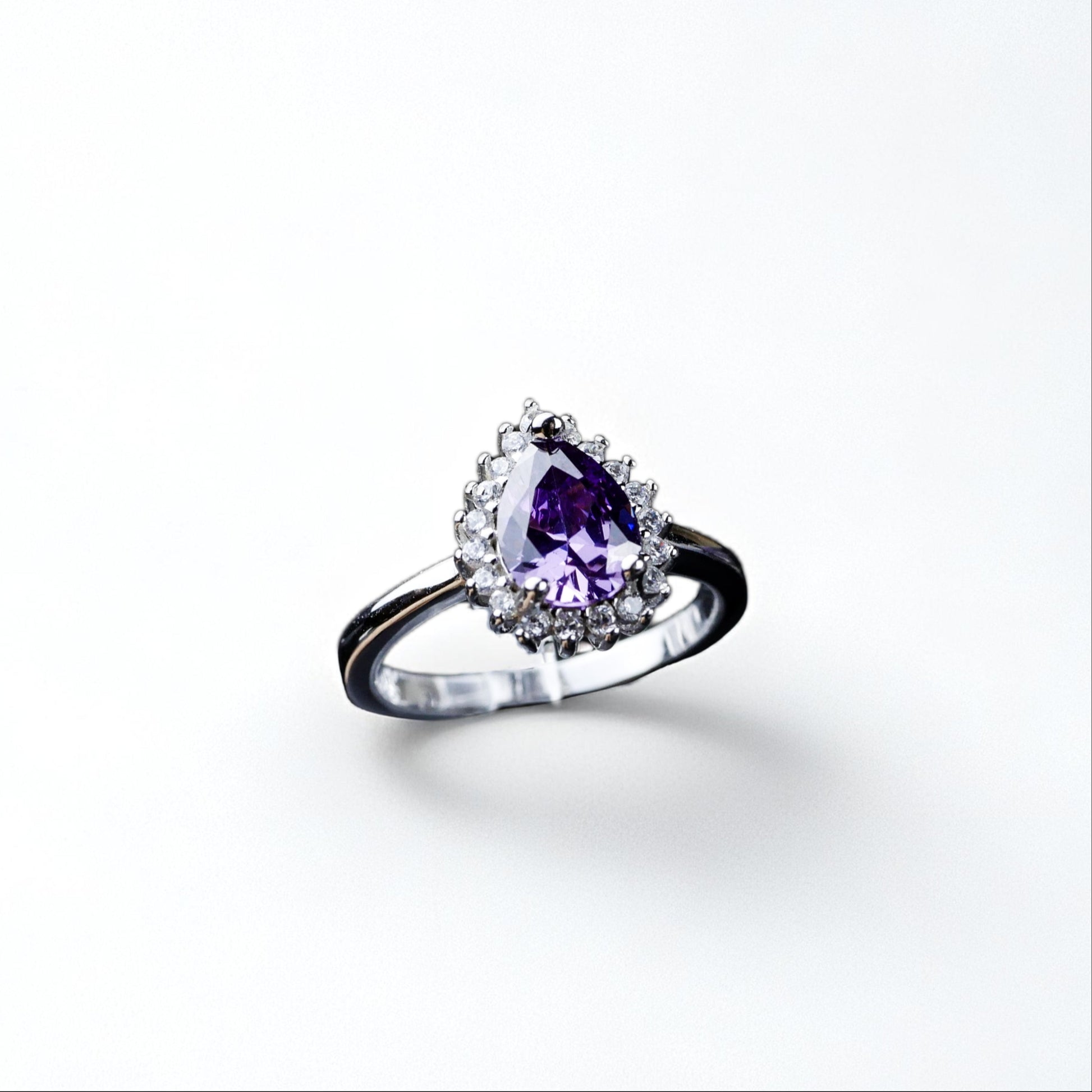 Silver ring with a purple gemstone on a white background