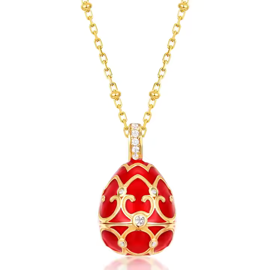 A red and gold-colored hollow pendant locket with intricate designs and a rhodium plating, suspended from a gold chain.