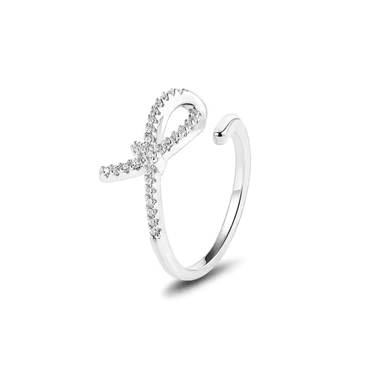 An adjustable sterling silver ring with a cubic zirconia bow design, featuring a rhodium plating.