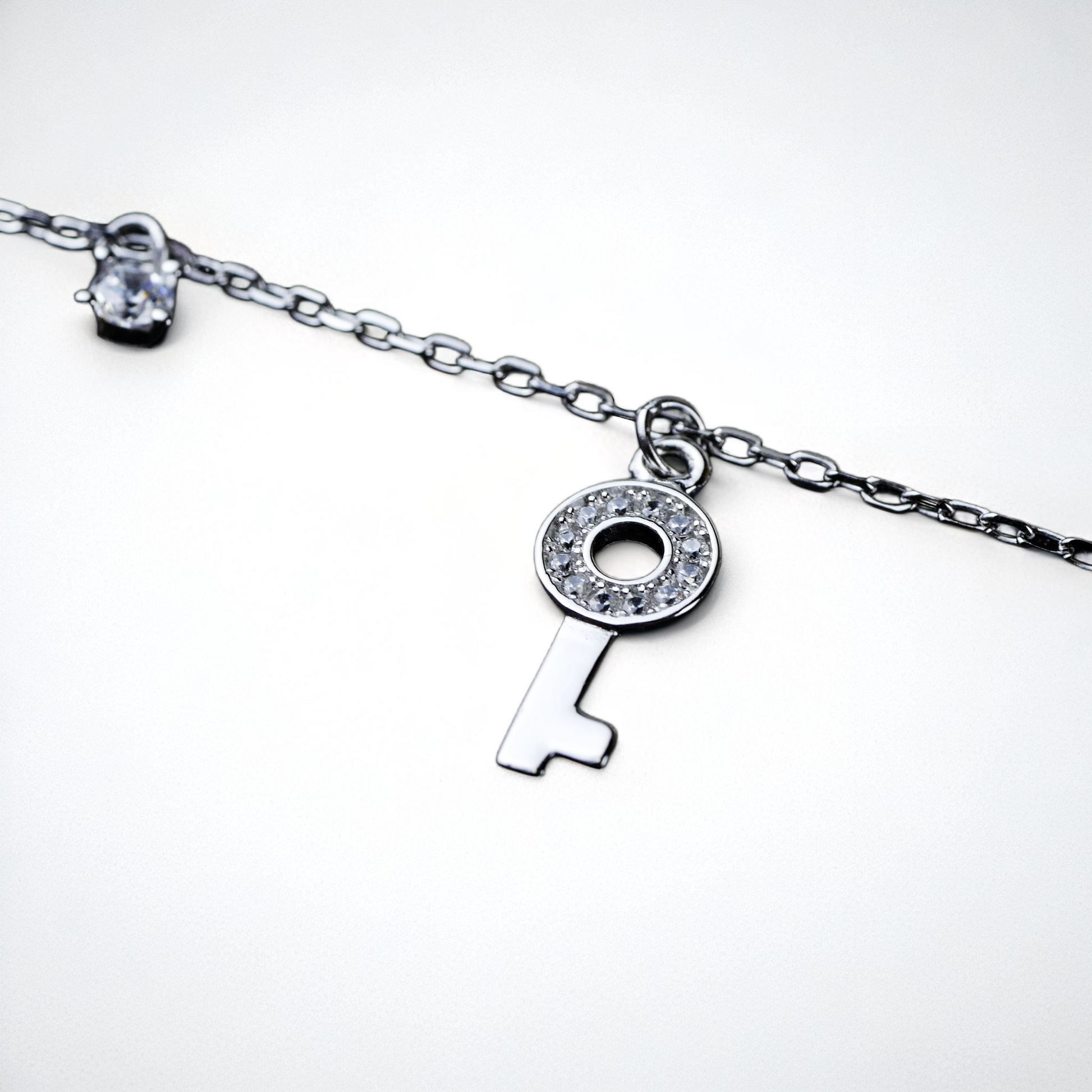 Silver key-shaped pendant on a chain against a white background